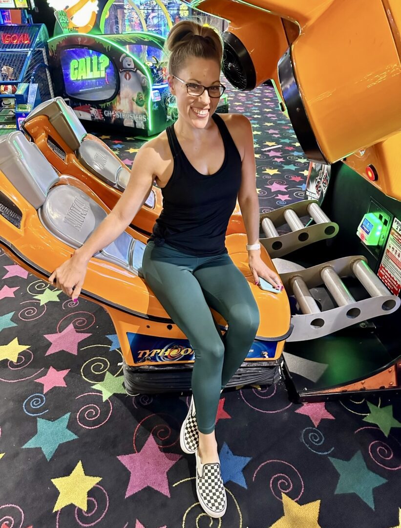 Woman playing arcade game at fun center.