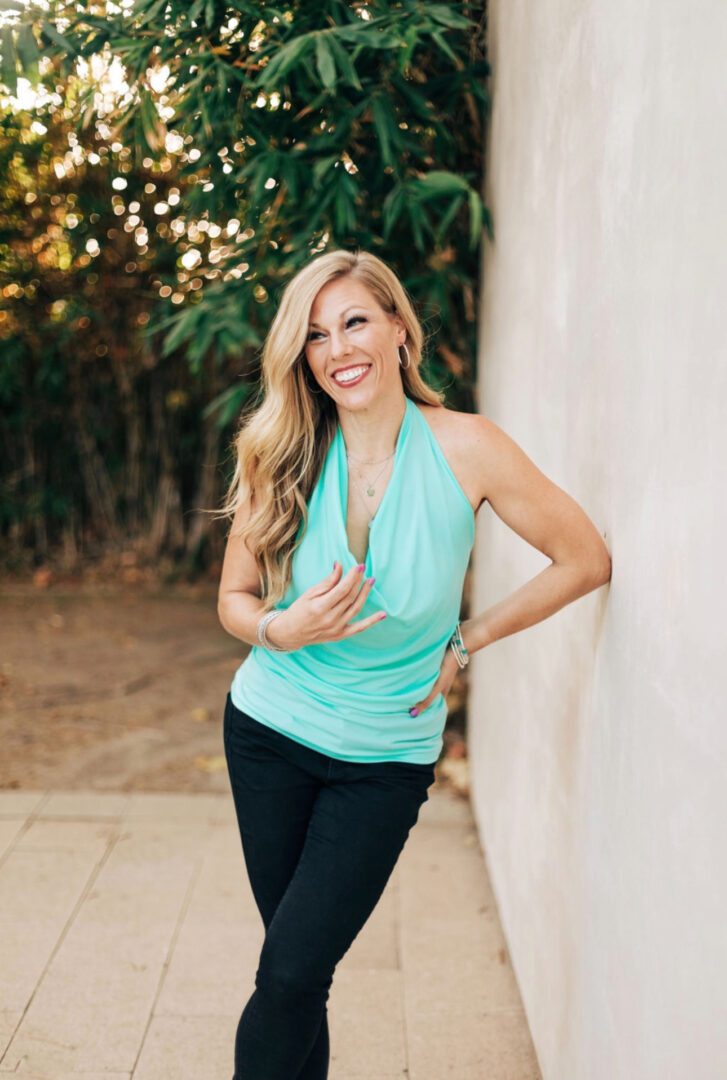 Smiling woman in teal halter top.